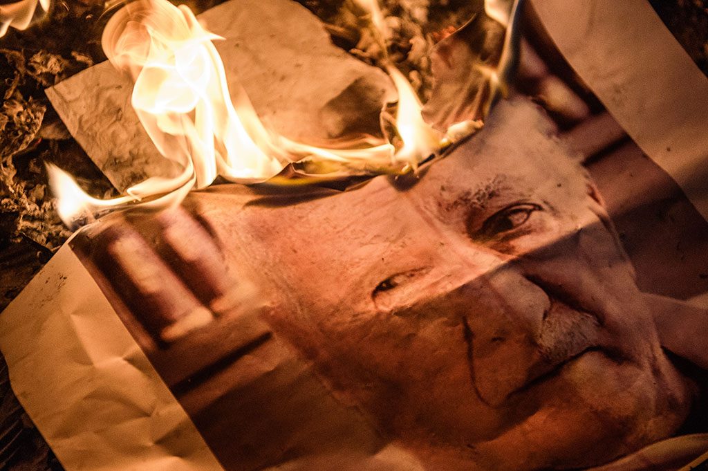 A picture taken on July 18, 2016 shows a poster picturing US-based preacher Fethullah Gulen burning during a Pro-Erdogan supporters rally at Taksim square in Istanbul on July 18, 2016 following the military failed coup attempt of July 15.Turkish security forces on July 18 carried out new raids against suspected plotters of the botched coup against the rule of President Recep Tayyip Erdogan, as international concern grew over the scale of the crackdown. Thousands of pro-Erdogan supporters waving Turkish flags filled the main Kizilay Square in Ankara while similar scenes were seen in Taksim Square in Istanbul, AFP photographers said. / AFP PHOTO / OZAN KOSE