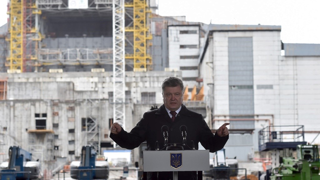 Ukrainian President Petro Poroshenko gives a speech in front of the Chernobyl Nuclear Power Plant sarcophagus, a massive steel and concrete structure covering the nuclear reactor No. 4 building of the Plant, during a commemoration ceremony on April 26, 2016. 
Ukraine marks 30 years since the world's worst nuclear accident at Chernobyl killed thousands and forced a global rethink about the wisdom of relying on atomic fuel. / AFP PHOTO / Genya SAVILOV