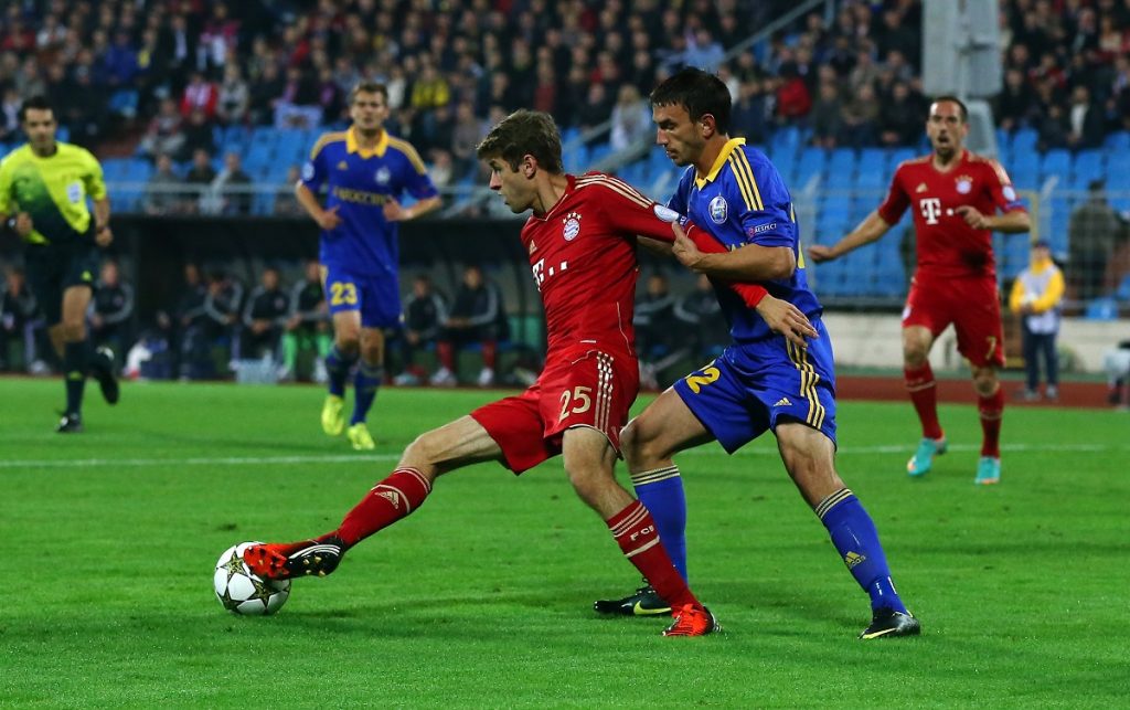 MINSK, BELARUS - OCTOBER 02: Marko Simic (R) of Borisov and Thomas Mueller (L) of Muenchen battle for the ball the during UEFA Champions League group F match between FC Bayern Muenchen and FC BATE Borisov at Dinamo Stadium on October 2, 2012 in Minsk, Belarus.  (Photo by Martin Rose/Bongarts/Getty Images)