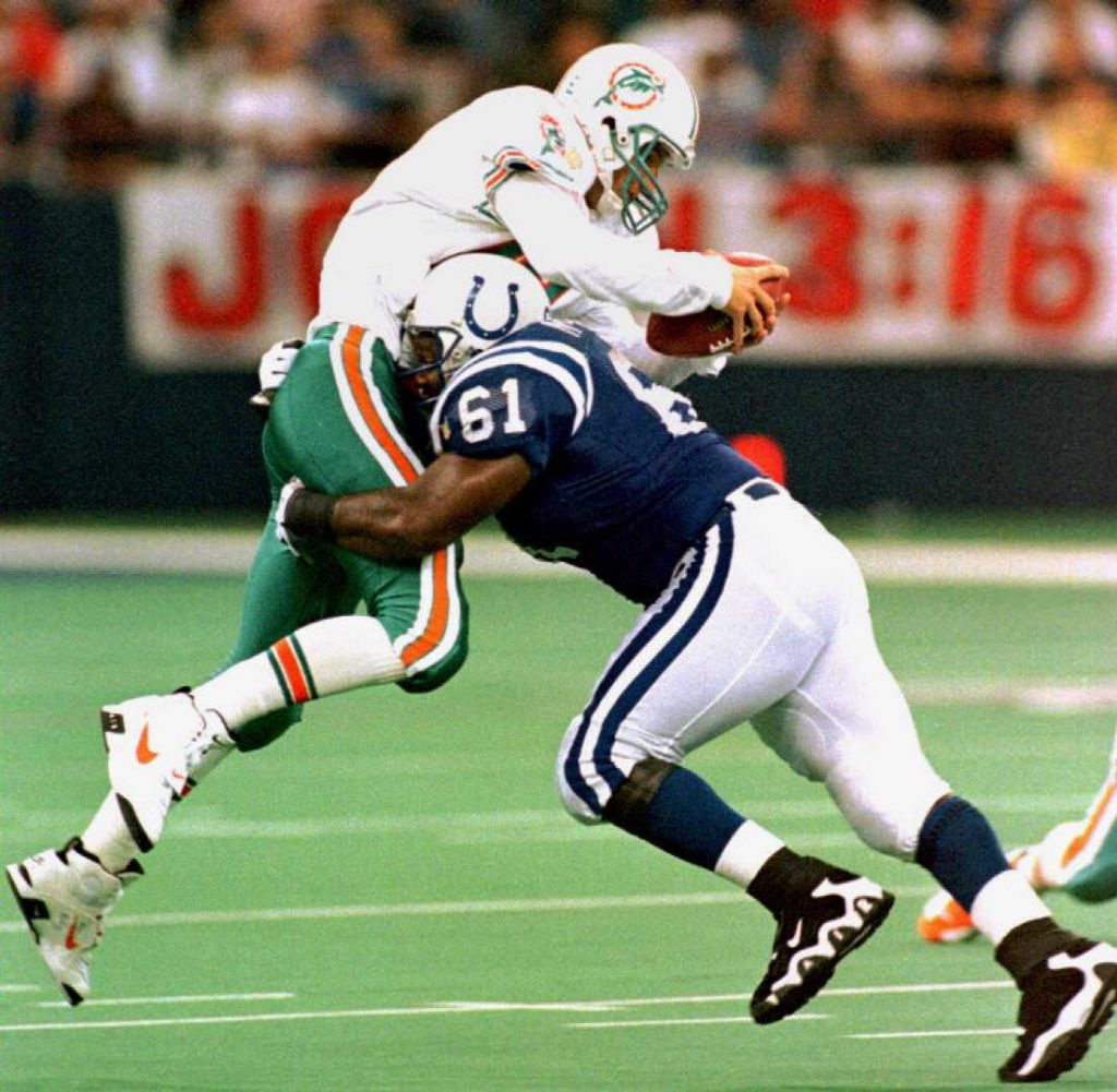 Indianapolis Colt defesive tackle Tony McCoy (61) sacks Miami Dolphins quarterback Bernie Kosar (19) during third quarter action 23 September at the RCA Dome in Indianapolis, IN.  The Colts won 10-6 and are 4-0, while the Dolphins fall to 3-1. AFP Photo/John RUTHROFF / AFP PHOTO / JOHN RUTHROFF