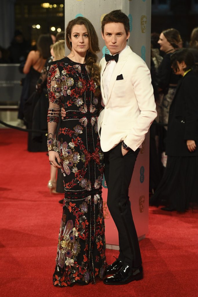 British actor Eddie Redmayne (R) and his wife Hannah Bagshawe (L) pose upon arrival at the BAFTA British Academy Film Awards at the Royal Albert Hall in London on February 12, 2017. / AFP PHOTO / Justin TALLIS