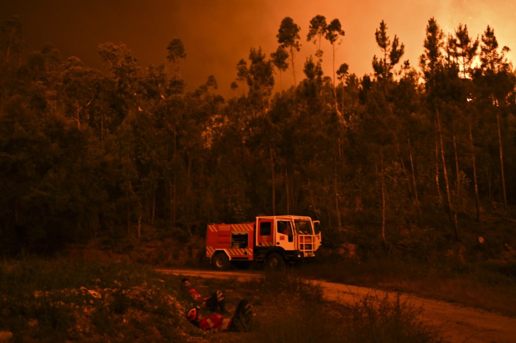 Firefighters rest during a wildfire at Penela, Coimbra, central Portugal, on June 18, 2017. 
A wildfire in central Portugal killed at least 25 people and injured 16 others, most of them burning to death in their cars, the government said on June 18, 2017. Several hundred firefighters and 160 vehicles were dispatched late on June 17 to tackle the blaze, which broke out in the afternoon in the municipality of Pedrogao Grande before spreading fast across several fronts.    / AFP PHOTO / PATRICIA DE MELO MOREIRA