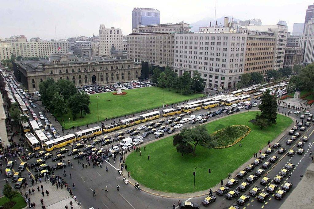 Dozens of taxis and buses block the streets of Santiago's Alameda neighborhood in front of the La Moneda Presidential Palace 22 March, 2001.  The drivers are protesting the lack of access to the area and are demanding wider use of the streets in the neighborhood.  AFP PHOTO / Matias RECART / AFP PHOTO / MATIAS RECART