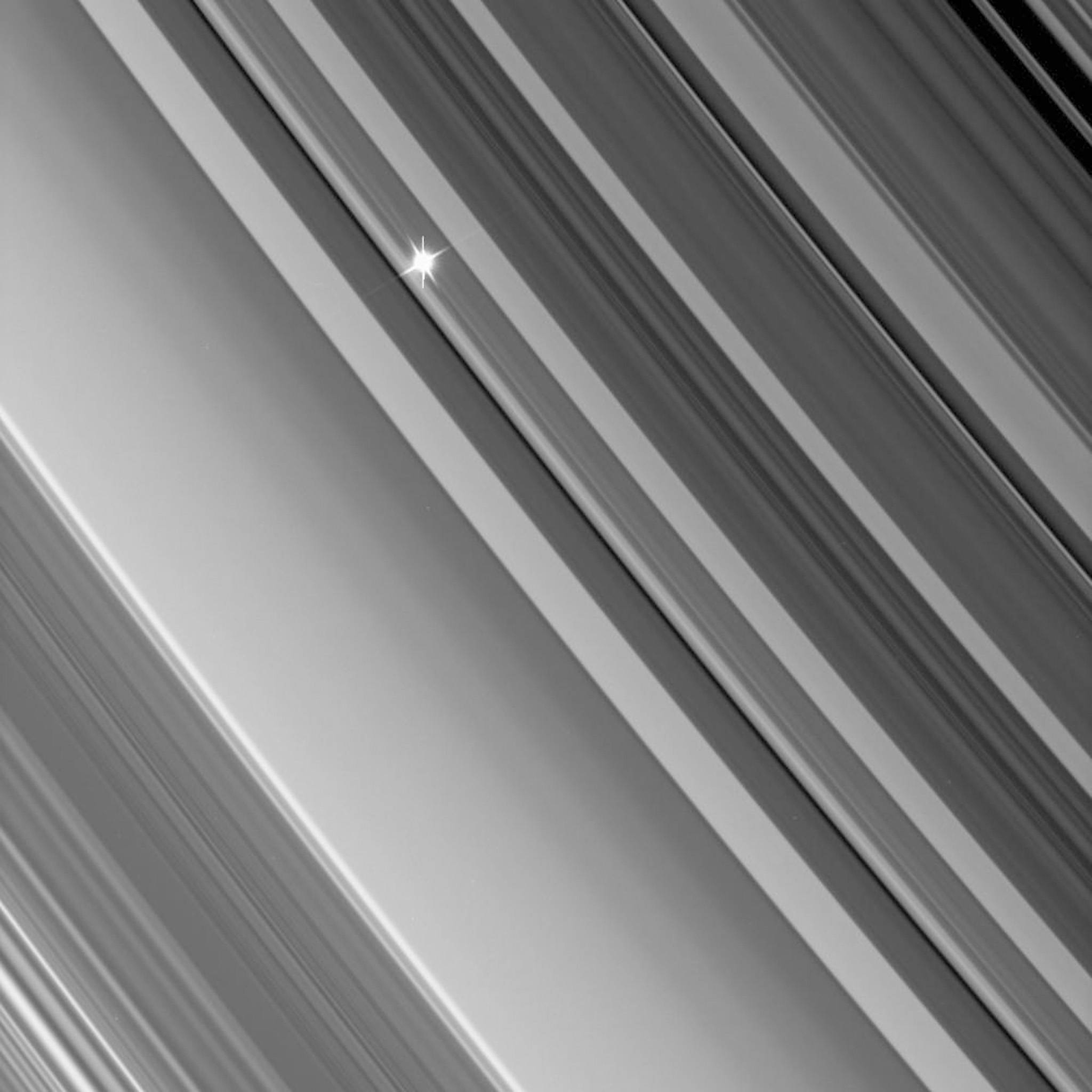 This NASA handout image released 16 October 2006 shows a view from the Cassini spacecraft as it looks through the dense B ring toward a distant star in an image from a recent stellar occultation observation. These observations point the camera toward a star whose brightness is well known. Then, as Cassini watches the rings pass in front, the star's light fluctuates, providing information about the concentrations of ring particles within the various radial features in the rings. This view looks toward the unlit side of the rings from about 35 degrees above the ringplane. The star's image is partly saturated, causing the vertical lines that extend up and down. The image was taken in visible light with the Cassini spacecraft narrow-angle camera on 26 September, 2006 at a distance of approximately 543,000 kilometers (338,000 miles) from Saturn and at a Sun-Saturn-spacecraft, or phase, angle of 106 degrees. Image scale is about 3 kilometers (2 miles) per pixel. AFP PHOTO/NASA/JPL/SPACE SCIENCE INSTITUTE =GETTY OUT=

 / AFP PHOTO / NASA/JPL / HO