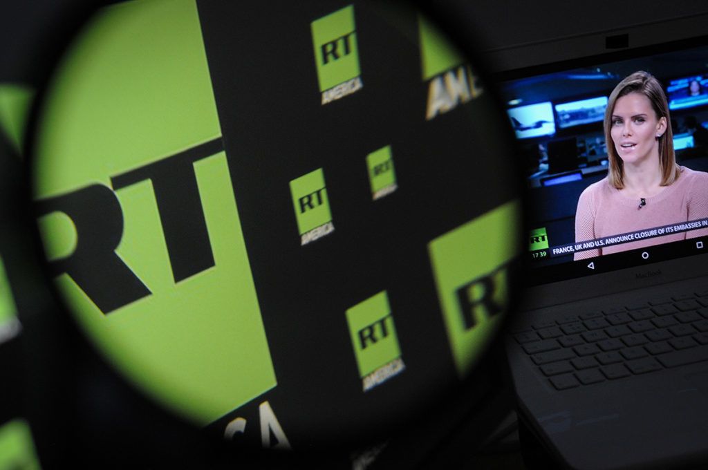 The Russia Today logo is seen on a computer screen on November 10, 2017 while a broadcast is seen in the background. (Photo by Jaap Arriens/NurPhoto)