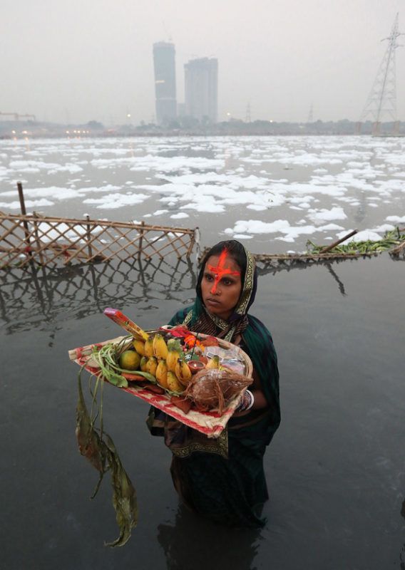 Újdelhi, 2018. január 9.A 2018. január 9-én közreadott képen a Jamuna folyó vegyszerhabbal borított vizében áll egy felajánlást tevő indiai nő a Csat Púdzsa hindu ünnep alkalmából Újdelhiben 2017. október 26-án. A Himalája Jamunotri-gleccserének kristálytiszta olvadékvizéből eredő folyó az indiai fővároson keresztül Uttar Prades szövetségi államban ömlik a Gangeszbe. Mindkét folyót vallásos tisztelet övezi, mivel a hinduk hite szerint a szent vizekben való megmártózás megszabadít a halál gyötrelmeitől. (MTI/EPA/Haris Tjagi)