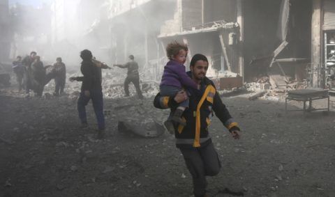 A Syrian man carries a child injured in government bombing in the rebel-held town of Hamouria, in the besieged Eastern Ghouta region on the outskirts of the capital Damascus, on February 19, 2018.
Heavy Syrian bombardment killed 44 civilians in rebel-held Eastern Ghouta, as regime forces appeared to prepare for an imminent ground assault. / AFP PHOTO / ABDULMONAM EASSA