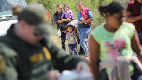 MCALLEN, TX - JUNE 12: Central American asylum seekers wait as U.S. Border Patrol agents take them into custody on June 12, 2018 near McAllen, Texas. The families were then sent to a U.S. Customs and Border Protection (CBP) processing center for possible separation. U.S. border authorities are executing the Trump administration's "zero tolerance" policy towards undocumented immigrants. U.S. Attorney General Jeff Sessions also said that domestic and gang violence in immigrants' country of origin would no longer qualify them for political asylum status.   John Moore/Getty Images/AFP