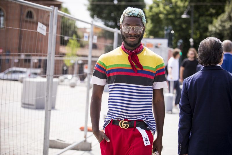 FLORENCE, ITALY - JUNE 14:   A guest, wearing striped t shirt, Gucci belt, red trousers and Adidas sneakers, is seen during the 94th Pitti Immagine Uomo at Fortezza Da Basso on June 14, 2018 in Florence, Italy. (Photo by Claudio Lavenia/Getty Images)