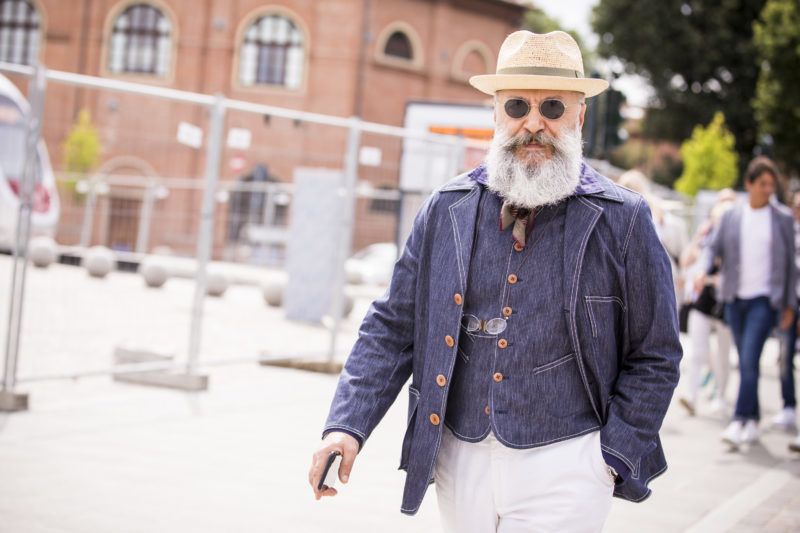 FLORENCE, ITALY - JUNE 14:   Gianni Fontana, wearing straw hat, denim blazer and vest and white trousers, is seen during the 94th Pitti Immagine Uomo at Fortezza Da Basso on June 14, 2018 in Florence, Italy. (Photo by Claudio Lavenia/Getty Images)