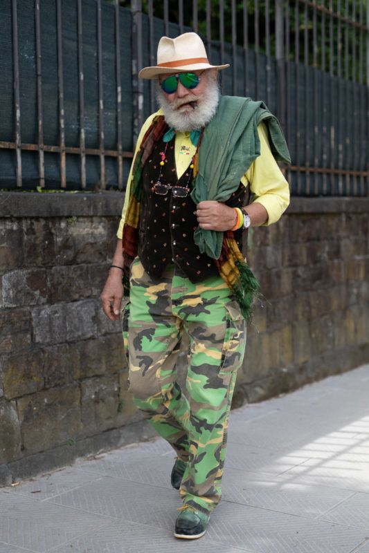 FLORENCE, ITALY - JUNE 14:A guest is seen during the 94th Pitti Immagine Uomo wearing a black vest, yellow shirt, green camo pants and hat on June 14, 2018 in Florence, Italy. (Photo by Matthew Sperzel/Getty Images)