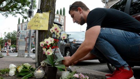 A man leaves flowers for the victims at the scene of last night shooting in Toronto, Ontario on July 23, 2018.
Toronto police were seeking to determine a motive on after a 29-year-old man opened fire with a handgun on restaurant goers and pedestrians in a busy neighborhood of Canada's largest city overnight, killing two people and wounding 13. The suspect, who has not been identified, was found dead in a nearby alley after an exchange of gunfire with police.
 / AFP PHOTO / Usman Khan