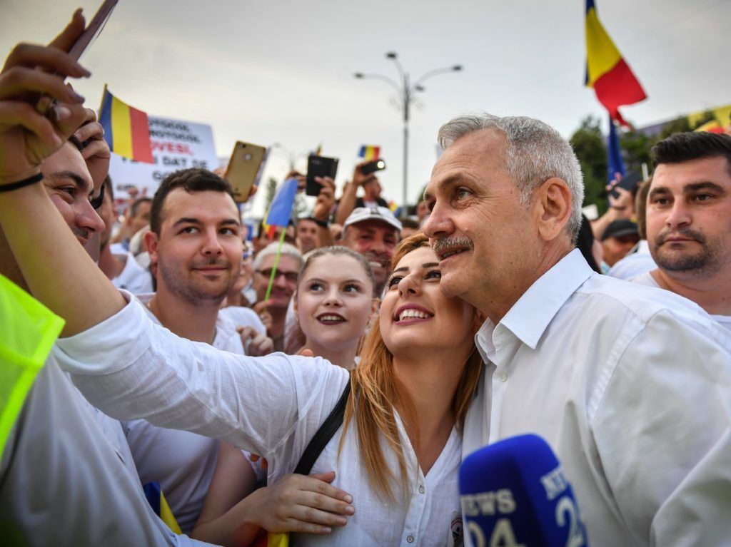 Romania's social democratic party (PSD) leader Liviu Dragnea (2nd R) poses for a selfie with a supporter at the Piata Victoriei square, next to the Romanian Government headquarters, during a support meeting organized by the PSD (Social Democrat Party) ruling party in Bucharest, June 9, 2018.
From busing supporters to Bucharest to mass mailings of party slogans, Romania's left-wing government was pulling out all the stops for the demonstration against the country's own judiciary. / AFP PHOTO / Daniel MIHAILESCU