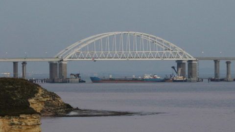 5711848 25.11.2018 A cargo ship blocks a passage under the arch of the Crimean bridge over Kerch Strait in Russia, November 25, 2018. On Sunday Russian authorities closed off the Kerch Strait after three Ukrainian naval ships had crossed the Russian border and entered the temporarily closed area of the Russian territorial waters.  Andrej Krylov / Sputnik