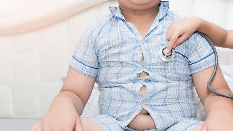 Little hand doctor check heart by stethoscope to obese asian boy, healthcare concept