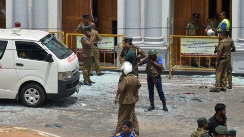 Sri Lankan security personnel stand next to an ambulance outside St. Anthony's Shrine in Kochchikade in Colombo on April 21, 2019 following a blast at the church. - At least 42 people were killed April 21 in a string of blasts at hotels and churches in Sri Lanka as worshippers attended Easter services, a police official told AFP. (Photo by ISHARA S.  KODIKARA / AFP)