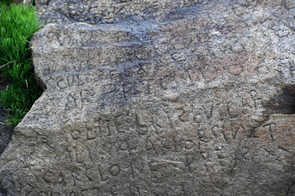 This picture taken on May 7, 2019 shows inscriptions composing indecipherable words on a rock in the Brittany village of Plougastel-Daoulas. - The city launched a national call with a 2000 euros reward to anyone able to solve the mystery of those inscriptions propably made during the 18th century. (Photo by Fred TANNEAU / AFP)