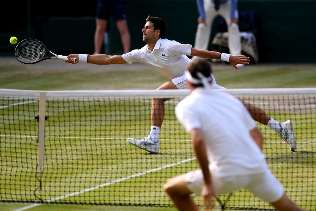 LONDON, ENGLAND - JULY 14: Novak Djokovic of Serbia stretches to play a forehand in his Men's Singles final against Roger Federer of Switzerland during Day thirteen of The Championships - Wimbledon 2019 at All England Lawn Tennis and Croquet Club on July 14, 2019 in London, England. (Photo by Matthias Hangst/Getty Images)