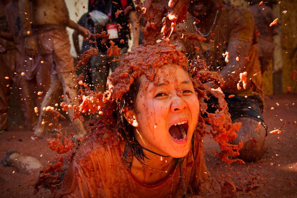 A reveller covered in tomato pulp participates in the annual "Tomatina" festival in the eastern town of Bunol, on August 28, 2019. - The iconic fiesta, which is billed at "the world's biggest food fight" has become a major draw for foreigners, in particular from Britain, Japan and the United States. (Photo by JAIME REINA / AFP)