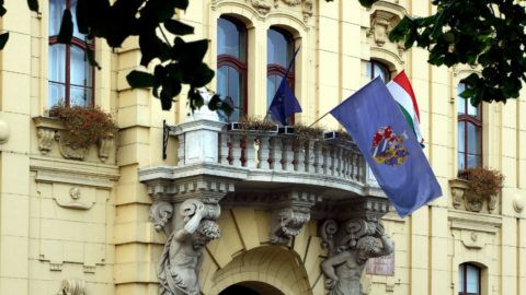 Szeged, 2018. november 3.
A város címeres zászlója leng a Városháza Lechner Ödön és Pártos Gyula tervei alapján 1883-ban megvalósult barokk épületének erkélyén, az EU csillagos zászlaja és a magyar nemzeti lobogó mellett. Az erkélyt atlaszok tartják.
MTVA/Bizományosi: Jászai Csaba 
***************************
Kedves Felhasználó!
Ez a fotó nem a Duna Médiaszolgáltató Zrt./MTI által készített és kiadott fényképfelvétel, így harmadik személy által támasztott bárminemû – különösen szerzõi jogi, szomszédos jogi és személyiségi jogi – igényért a fotó készítõje közvetlenül maga áll helyt, az MTVA felelõssége e körben kizárt.