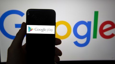 The logo of Google Play  is seen on a screen. In the background there is the logo of Google. Alphabet is the mother company of Google. It has a revenue of 117 billion dollars. (Photo by Alexander Pohl/NurPhoto)